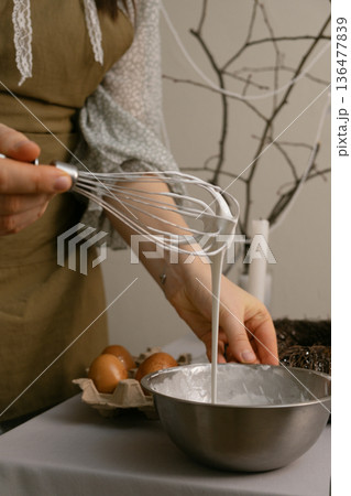 Quiet moment of joy before Easter, making traditional Easter cake at home in a cozy, warm kitchen setting. Quiet moment of joy before Easter, making traditional Easter cake at home in a cozy, warm kitchen setting. 136477839