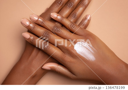 Hands are applying a clean, nourishing skincare product on soft, radiant skin in a tranquil and minimal environment 136478199