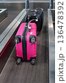 A pink suitcase with a baggage tag at an airport check-in counter at Milano Malpensa Airport (MXP) 136478392