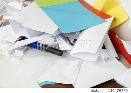 Disorganized Workspace with Scattered Papers and School Supplies at Home 136479770