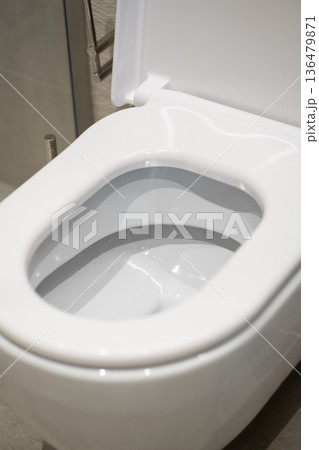 White ceramic toilet bowl with lid open, representing modern bathroom design, hygiene, cleanliness, and plumbing technology for residential and commercial sanitation White ceramic toilet bowl with lid open, representing modern bathroom design, hygiene, cleanliness, and plumbing technology for residential and commercial sanitation 136479871