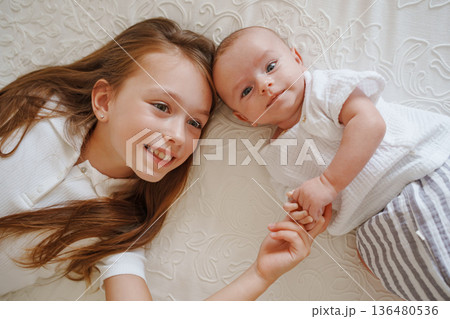 Sibling bond during playtime on a soft blanket Sibling bond during playtime on a soft blanket 136480536