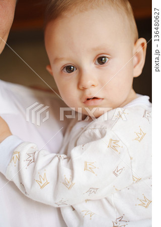 Child in cozy outfit snuggled in caregiver's arms Child in cozy outfit snuggled in caregiver's arms 136480627