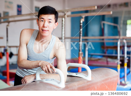 Portrait of asian gymnast in gym near pommel horse 136480692