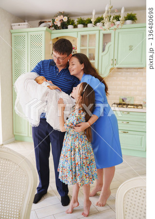 Family gathers to welcome new baby in cheerful kitchen Family gathers to welcome new baby in cheerful kitchen 136480698
