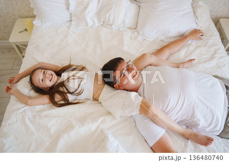 Father and daughter play on bed in morning light Father and daughter play on bed in morning light 136480740