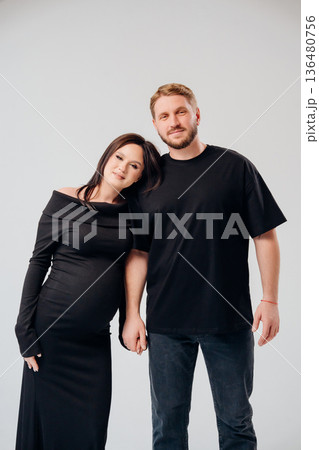 Couple poses together in a studio for maternity celebration 136480756
