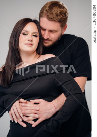 Couple embracing during maternity photo session in studio Couple embracing during maternity photo session in studio 136480804