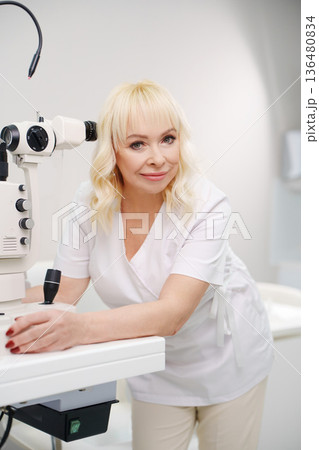 Ophthalmologist working with eye examination equipment Ophthalmologist working with eye examination equipment 136480834