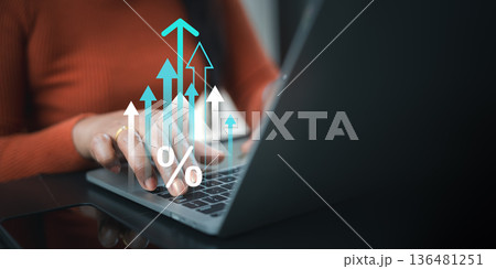 Business woman using laptop with virtual rising arrows and percentage icon, depicting interest rate increase, financial growth, investment profit, and economic success in digital marketing trend. 136481251