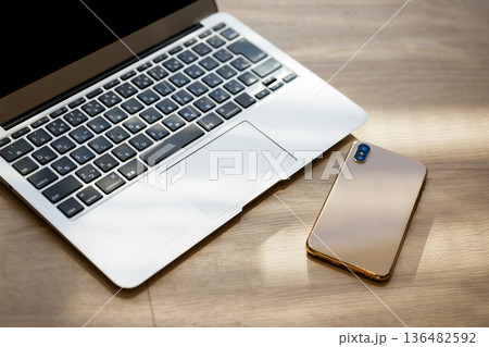 机の上に置かれたスマートフォンとPC 136482592