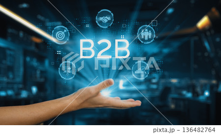 Hand Reaching Out Towards B2B Business Concepts with Digital Icons Representing Collaboration, Strategy, and Technology in Modern Workspace. Auvana 136482764
