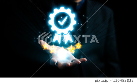 Glowing Badge of Approval in Hand with Stars and Light Effects Signifying Quality and Achievement in Dark Background. Qubit Glowing Badge of Approval in Hand with Stars and Light Effects Signifying Quality and Achievement in Dark Background. Qubit 136482835