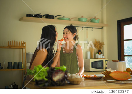 LGBT couple sharing fresh papaya in a cozy kitchen, smiling together while preparing healthy food and enjoying a warm, intimate morning at home LGBT couple sharing fresh papaya in a cozy kitchen, smiling together while preparing healthy food and enjoying a warm, intimate morning at home 136483577