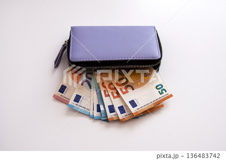 Close-up of euro bills inside a leather wallet. Security and modern financial tools. Close-up of euro bills inside a leather wallet. Security and modern financial tools. 136483742