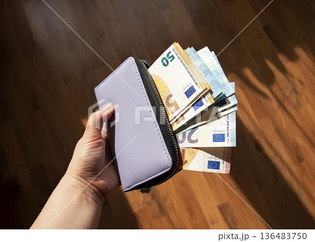 Leather wallet opened to reveal euro currency. Finance, budgeting, and careful money management. Leather wallet opened to reveal euro currency. Finance, budgeting, and careful money management. 136483750