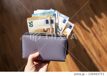 Leather wallet opened to reveal euro currency. Finance, budgeting, and careful money management. Leather wallet opened to reveal euro currency. Finance, budgeting, and careful money management. 136483751
