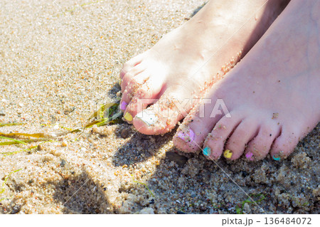 Woman feet with nail polish on sand 136484072