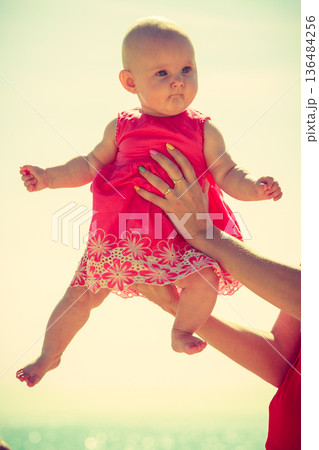 Little baby held by mother sunny day. 136484256