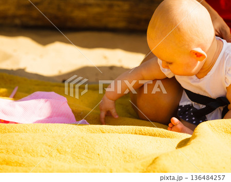 Little baby playing on beach during summertime Little baby playing on beach during summertime 136484257