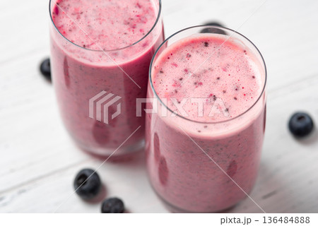 Two glasses of berry smoothie with chia and fresh berries on a white wooden table 136484888