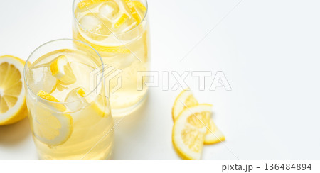 Homemade lemonade with lemon in two glasses on a white background Homemade lemonade with lemon in two glasses on a white background 136484894