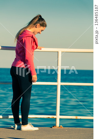 Woman doing sports exercises outdoors by seaside Woman doing sports exercises outdoors by seaside 136485187