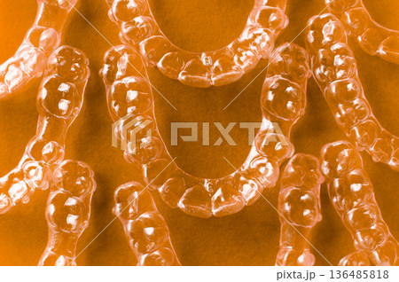 Clear aligners and braces on a colored background. Many clear hedgehog braces on a colored background. Dental background. Technological dentistry. 136485818