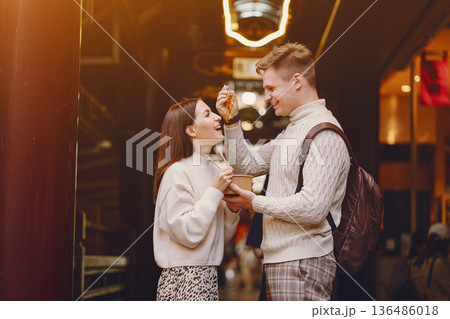 newlywed couple eating noodles with chopsticks in Shanghai outside a food market near Yuyuan. Couple eating authentic local food. husband and wife eating chinese food outisde of a food hall 136486018