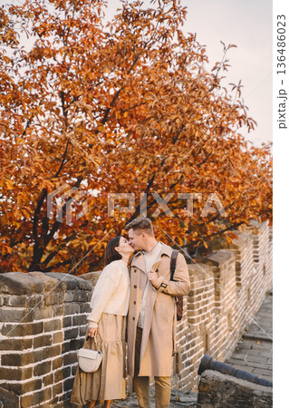 young couple kissing at the Great Wall of China. Newly married couple on their honeymoon to the Great Wall of China near Beijing China. 136486023