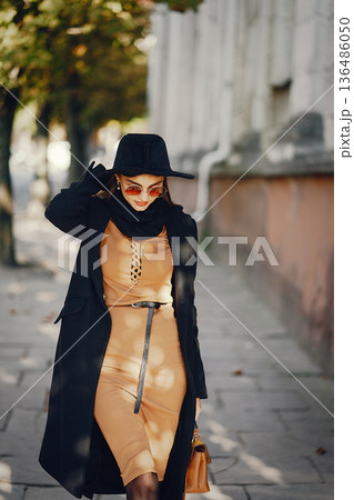 stylish girl walking through the city on a warm sunny autumn day stylish girl walking through the city on a warm sunny autumn day 136486050