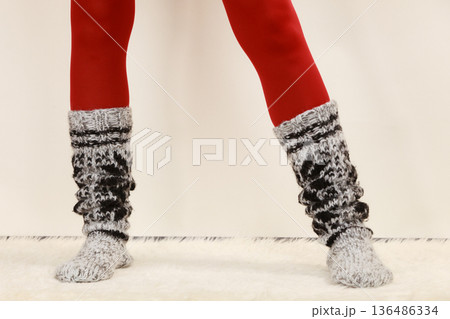 Woman legs wearing woolen socks and red tights 136486334