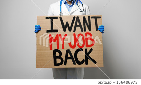 Doctor holding a sign asking to get job back in protest during work hours 136486975