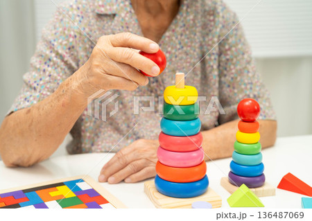 Asian elderly woman playing game. 136487069