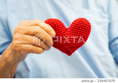 Asian senior patient woman holding red heart for health in hospital. Asian senior patient woman holding red heart for health in hospital. 136487070