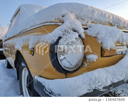 A yellow classic car waits in the snow-filled parking area A yellow classic car waits in the snow-filled parking area 136487609