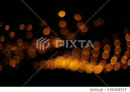 Golden Bokeh Lights on Black Background 136488537