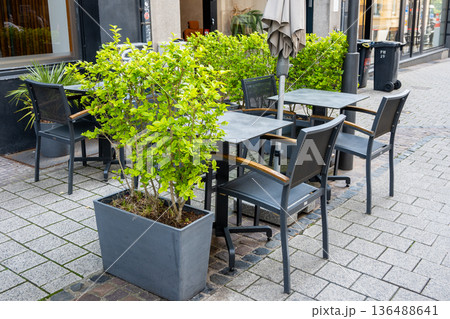 Cafe on the open air in Luxemburg. Chairs and tables outside with summer sun weather in France on the street. Design of furnitureset for summer cafe or restaurant. Cafe on the open air in Luxemburg. Chairs and tables outside with summer sun weather in France on the street. Design of furnitureset for summer cafe or restaurant. 136488641