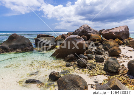 Coastal landscape, wet stones laying on white sands Coastal landscape, wet stones laying on white sands 136488837
