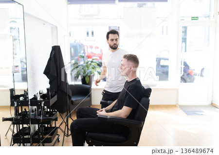 Barber consulting with client before professional haircut service Barber consulting with client before professional haircut service 136489674