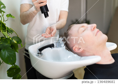 Client enjoying hair washing service in salon bowl 136489681