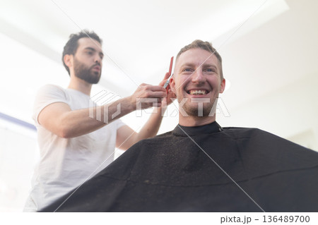 Man smiling enjoying haircut at barber salon 136489700