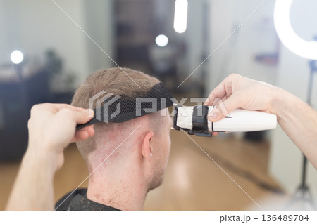 Barber giving client a fresh haircut in salon 136489704