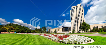 North Dakota State Capitol in Bismarck. Historic Art Deco skyscraper features a limestone facade and a flower bed spelling the state name on the lawn 136489720