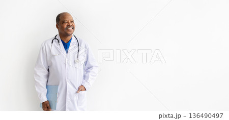 Mature black male doctor in white coat looking aside with gentle smile, Mature black male doctor in white coat looking aside with gentle smile, 136490497