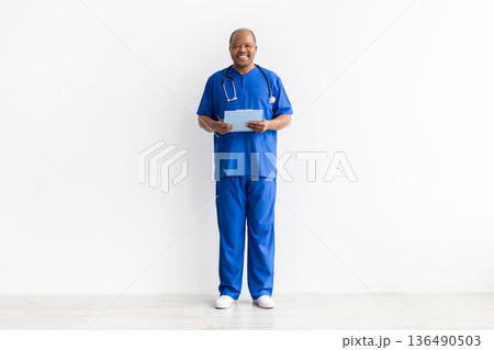 Full length portrait of mature black male doctor holding clipboard and pen Full length portrait of mature black male doctor holding clipboard and pen 136490503