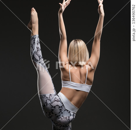 Slim blonde practicing yoga rearview Slim blonde practicing yoga rearview 136490762