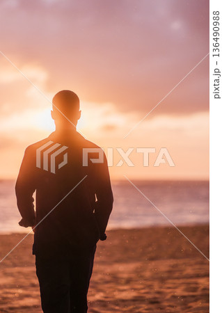 Man enjoying solitude on beach at sunset 136490988