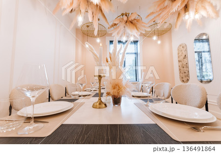 Neutral private dining table with pampas centerpiece, candlelight and modern decor Neutral private dining table with pampas centerpiece, candlelight and modern decor 136491864