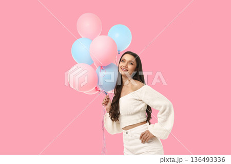 A woman holds colorful balloons during a birthday celebration A woman holds colorful balloons during a birthday celebration 136493336